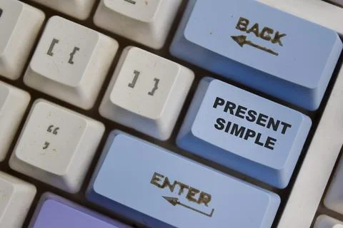 Present Simple one of the verb in modern english on the button keyboard Stock Photos