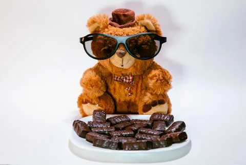 Present. Teddy bear in 3D glasses with chocolates. Stock Photos