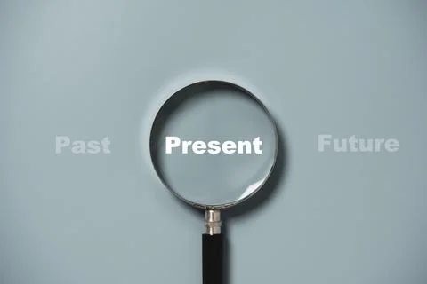 Present wording inside of Magnifier glass on blue background for focus curr.. Stock Photos