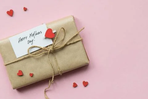 Present wrapped in brown craft paper and tie hemp string on Light pink bac... Stock Photos