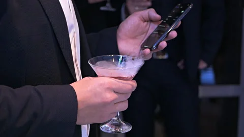 A presentable man in a classic suit holds a smoking cocktail in his hand and Video stock 121882374