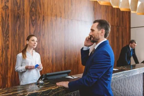 Presentable man standing at reception desk Stock Photos