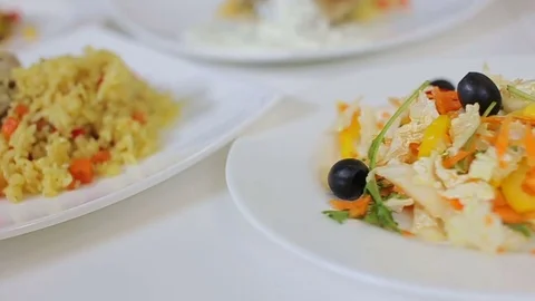 Presentation of pilaf with chicken served with salad of fresh vegetables and Stock Footage 78684192