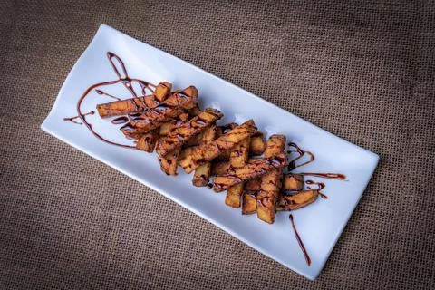 Presentation in a rectangular plate of aubergines cut into strips and fried,  Stock Photos