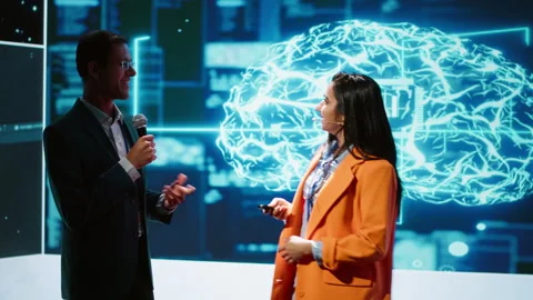 Presenter and guest chatting during AI summit discussion panel Stock Footage 278623964