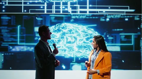 Presenter and guest chatting during AI summit discussion panel Stock Footage 278697637