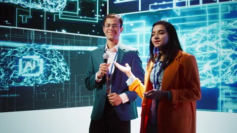 Presenter and guest talking at AI summit exploring latest tech developments Stock Footage 278626467