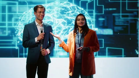Presenter and guest talking at AI summit exploring latest tech developments Stock Footage 278626607