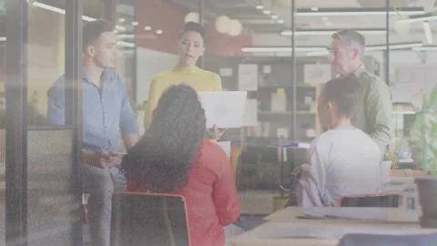 Presenter gesturing to laptop and showing animated chart, office team talking to Stock Footage 334013956