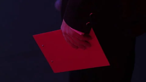 The presenter holds a red folder before going on stage. Stock Footage 248943093