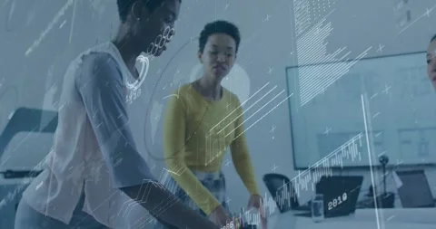 Presenter pointing at plans initiating charts with peer pointing at monitor in Stockbeeldmateriaal 330662376