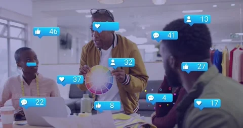 Presenter rotating color wheel driving social icons rising while team viewing Stock Footage 333904384