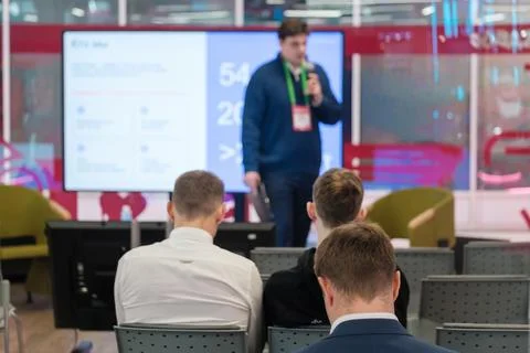 Presenter speaks beside data slide at conference Stock Photos