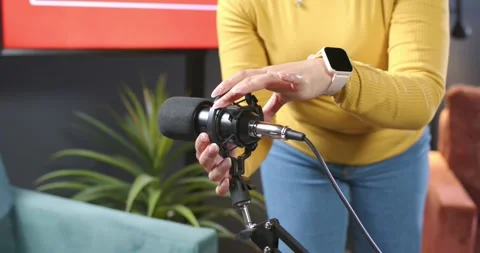 Presenter is stepping forward and adjusting shock mount to align microphone for Stock Footage 344964060