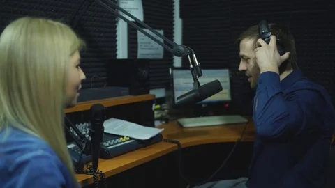 Presenters or moderators - man and woman - in radio station hosting show for Stock Footage 73570700