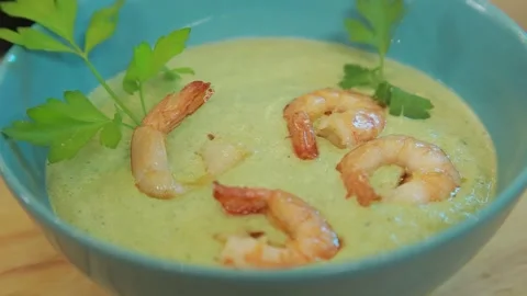 Presenting broccoli cream soup with shrimp and fresh herbs Stock Footage 340553781