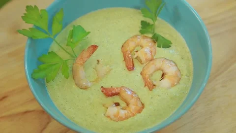 Presenting broccoli cream soup with shrimp and fresh herbs Stock Footage 340553904