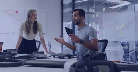 Presenting engineer holding tablet gesturing at drone prototypes in office with Stock Photos