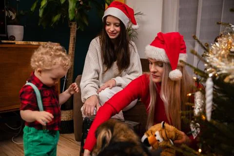 Presenting a gift to a two-year-old child. Mother and daughter are sitting next 写真素材