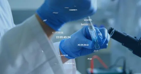 Presenting gloved hand in lab coat holding test tube near microscope in lab, 스톡 사진