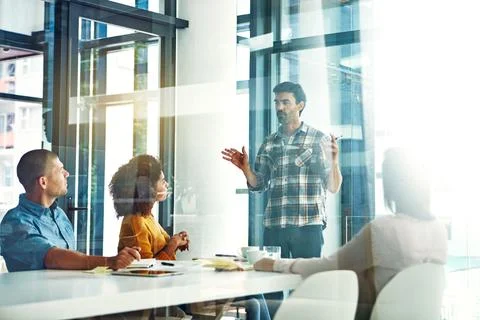 Presenting his ideas to the team. a young businessman giving a presentation in Stock Photos
