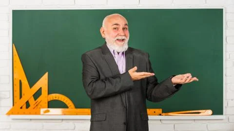 Presenting product. get knowledge here. senior man teacher use math tools 写真素材