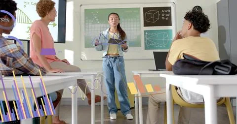 Presenting student in denim jacket holding triangle model at classroom front, Stock Photos