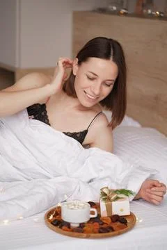 Presents, coffee and sweet awaking woman Foto stock