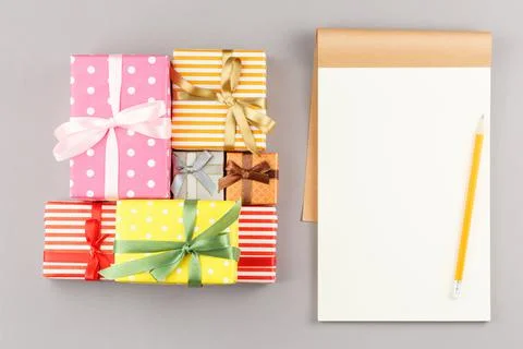 Presents in colored paper with an open notebook. Stock Photos