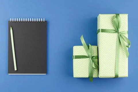Presents in colored paper with an open notebook. Stock Photos