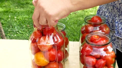 Preservations, conservation Salted pickled tomatoes in a jars on an wooden table Stock Footage 246078301