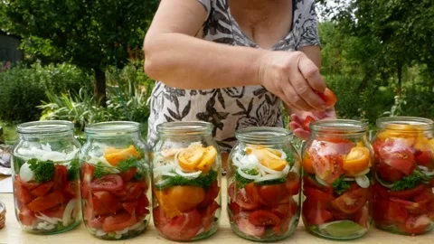 Preservations, conservation Salted pickled tomatoes in a jars on an wooden table Stock Footage 246078454