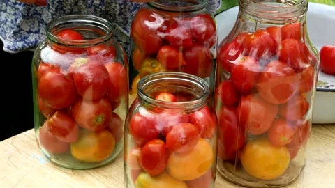 Preservations, conservation Salted pickled tomatoes in a jars on an wooden table Stock Footage 247559172