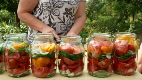 Preservations, conservation Salted pickled tomatoes in a jars on an wooden table Stock Footage 247559262