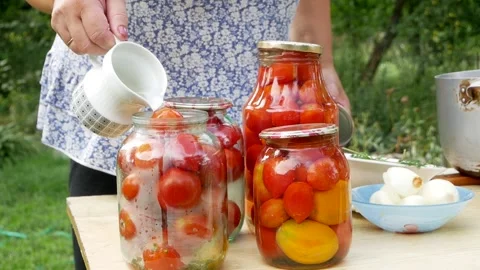 Preservations, conservation Salted pickled tomatoes in a jars on an wooden table Stock Footage 247559370