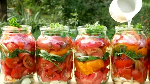 Preservations, conservation Salted pickled tomatoes in a jars on an wooden table Stock Footage 248301005