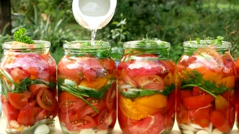 Preservations, conservation Salted pickled tomatoes in a jars on an wooden table Stock Footage 250068754