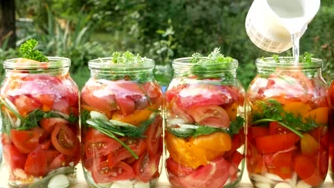 Preservations, conservation Salted pickled tomatoes in a jars on an wooden table Stock Footage 251827193