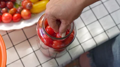 Preserving cherry tomatoes in glass jars Stock Footage 318574485