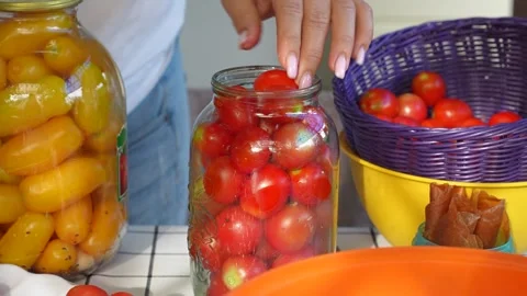 Preserving cherry tomatoes in glass jars Stock Footage 318574493