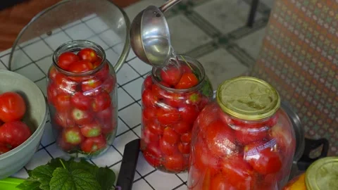Preserving cherry tomatoes in glass jars Stock Footage 318574497