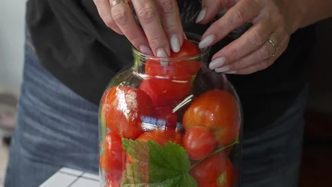 Preserving cherry tomatoes in glass jars Stock Footage 318574503