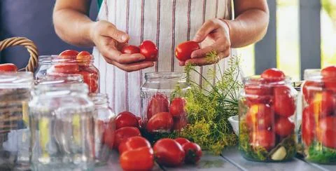 Preserving tomatoes in jars. Selective focus. Foto stock