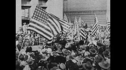 President Theodore Roosevelt waving at people while passing through crowd Stock Footage
