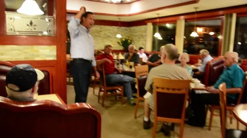 Presidential Candidate Rick Santorum talks to a small group of voters in a diner Stock Footage 152471583