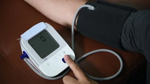 Press the button to turn on the blood pressure monitor. Stock Footage 171669528