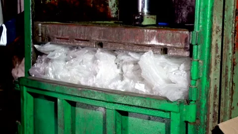 Press, plastic recycling. Compress polyethylene household waste with a hydraulic Stock Footage 137799759