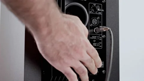 Press the power button and insert the cable into the speaker Stock Footage 198010950