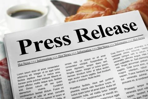 Press Release newspaper layout on a breakfast table with a blurry cup of co.. Stock Photos