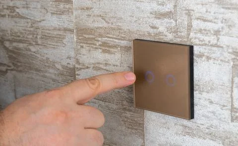 Press the touch switch button with your finger. Stock Photos